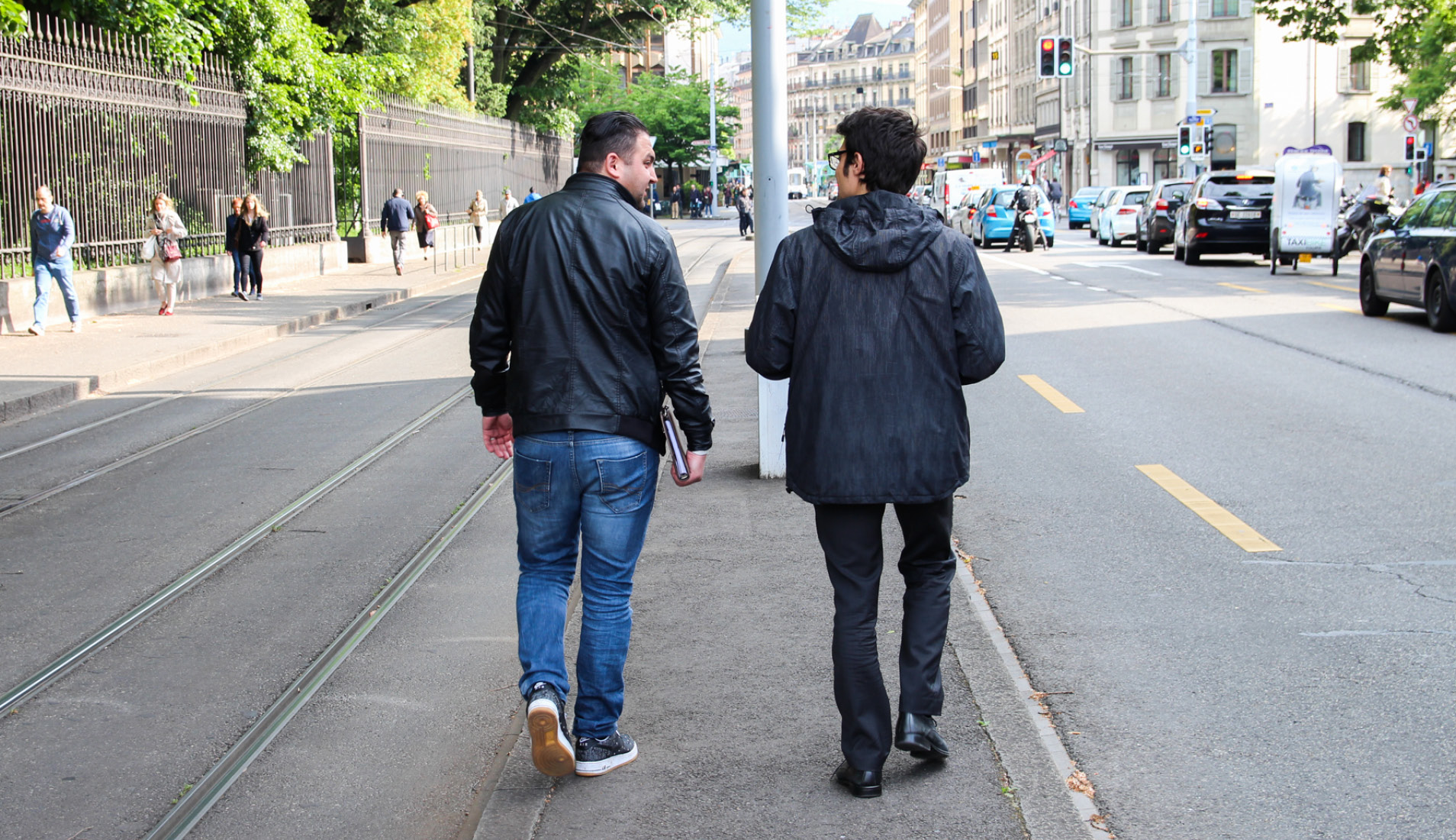 Deux personnes marchant dans les rues de Carouge pour une étude prospective.